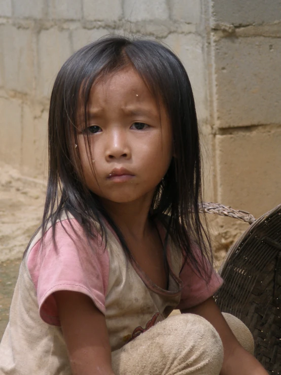 a child sits in the corner with one hand resting on her chest