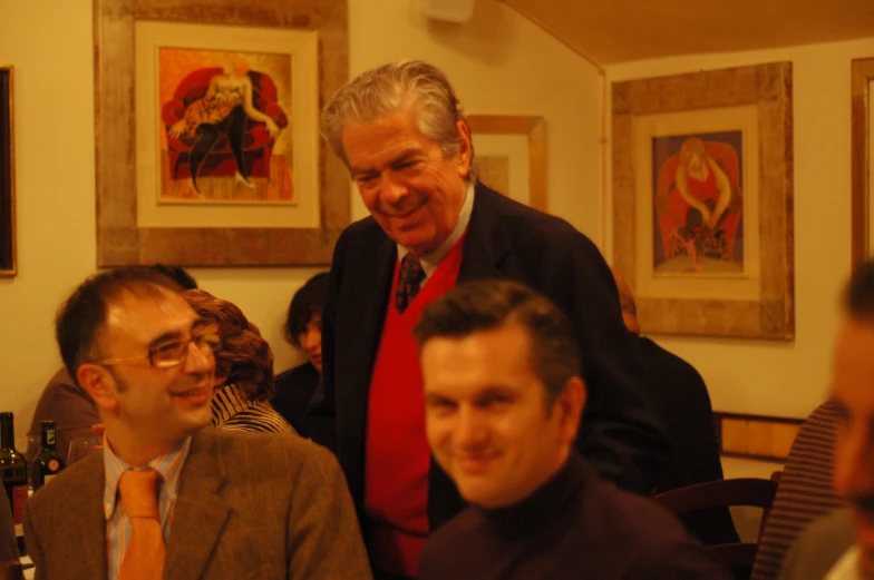 two men in red and one man in brown and white are smiling for the camera