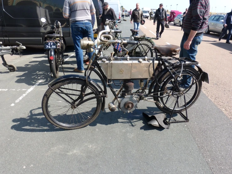 men looking at an old bicycle made from spare parts