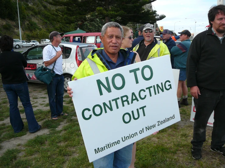 a group of people are holding a sign saying no to contructing out