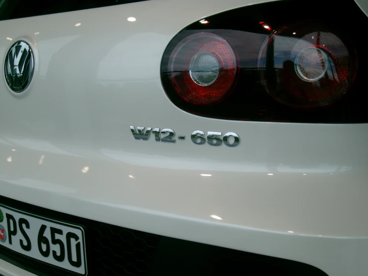 the rear view of a white car with a license plate