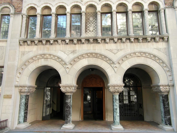 an ornate archway with marble columns is in the center of a large courtyard