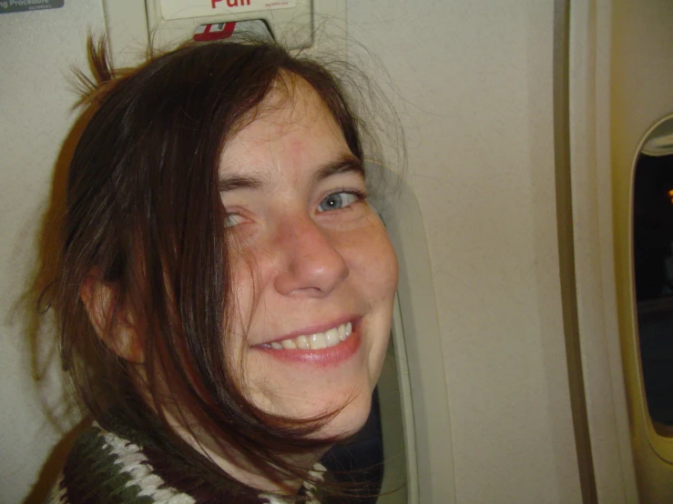 a woman sitting on a plane with her eyes open