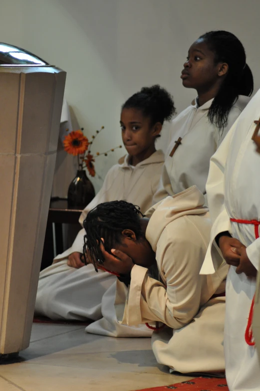 three people sitting on the floor at a service