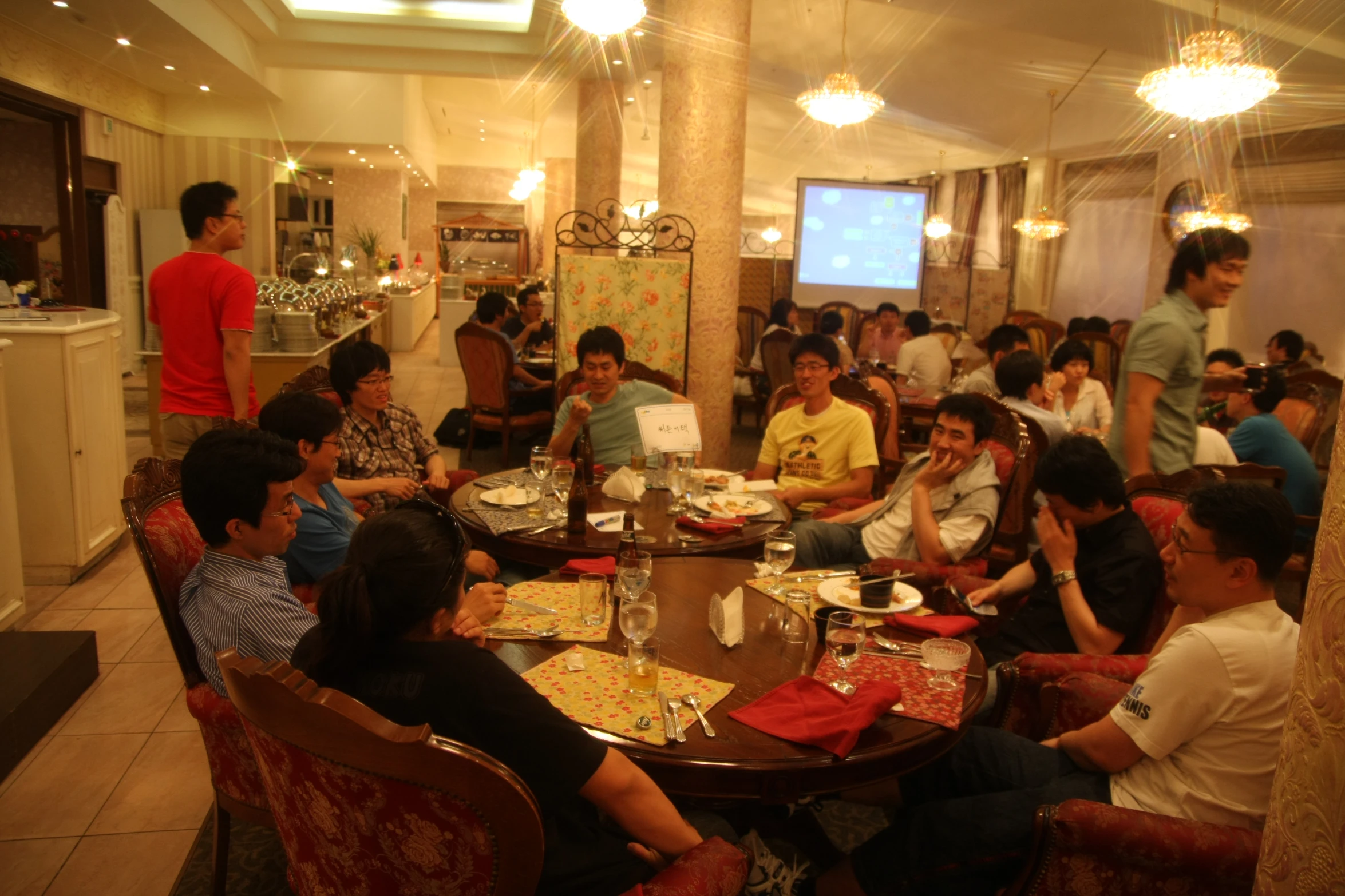 many people are sitting around a small table with food