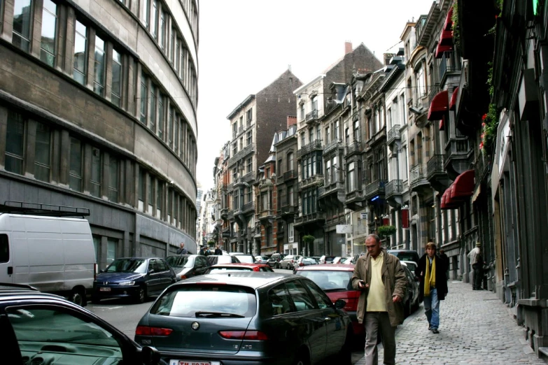 two men walk down a crowded city street