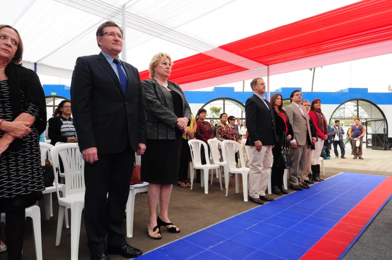 group of people standing at a ceremony dressed in suits