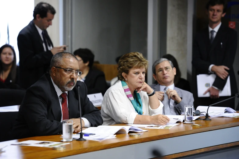 a group of people sitting at a table in a meeting room