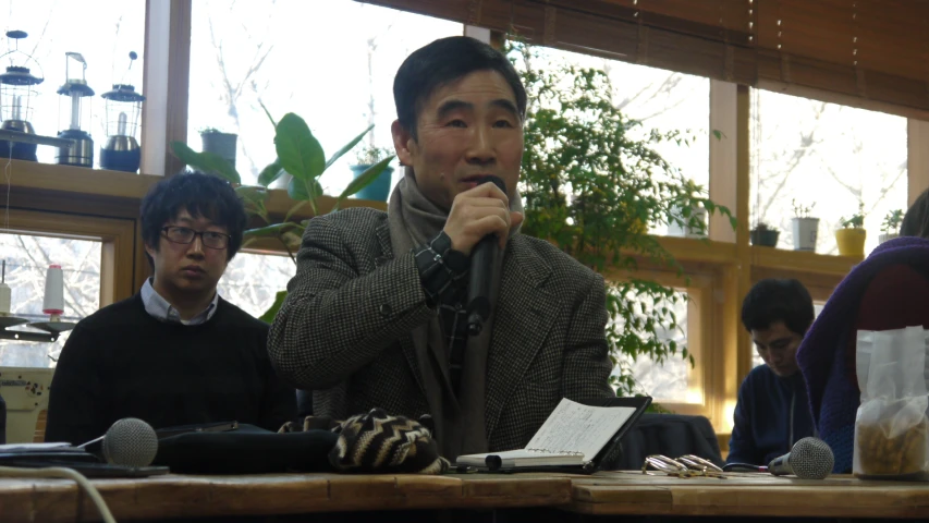 a man holding up a microphone in front of three people