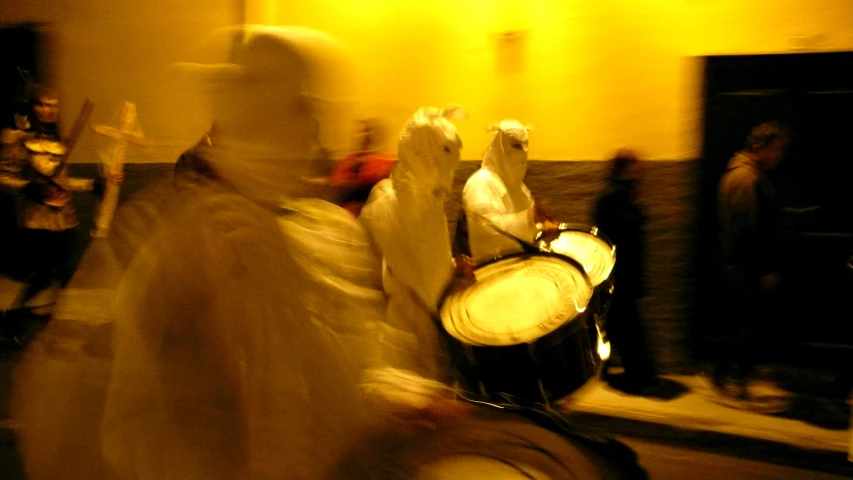 a person is wearing a white veil and holding a drum