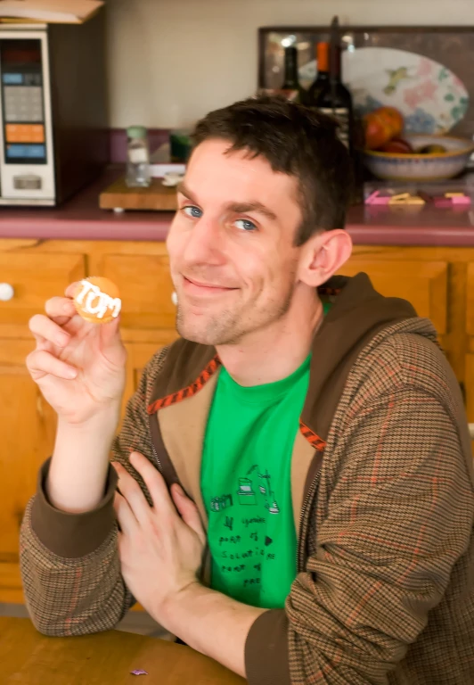 a man poses for a po while eating a doughnut