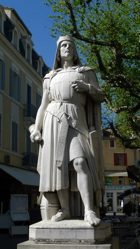 a large statue on a city street next to a building