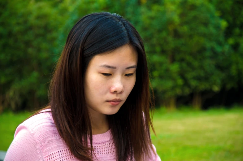 a woman in a pink top is looking down