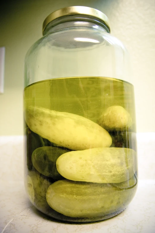 a jar filled with cucumber slices on top of a table
