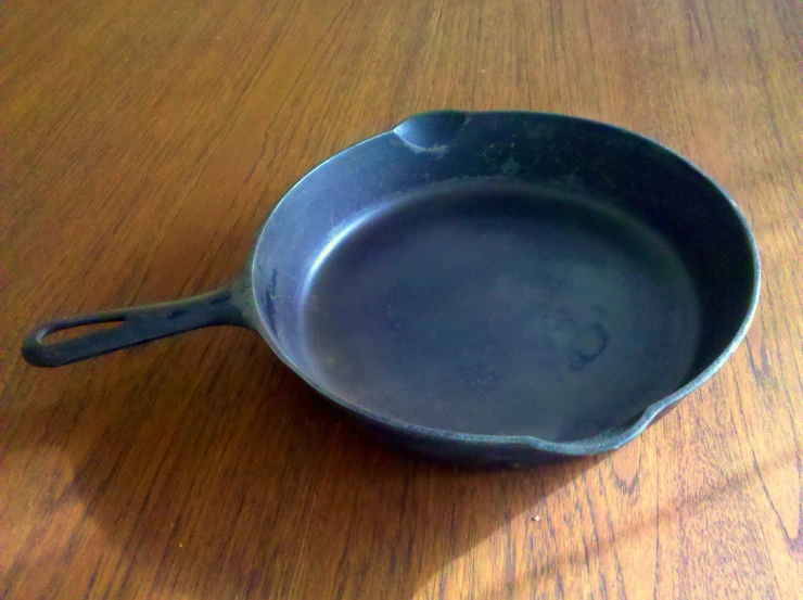 a small frying pan is sitting on a wooden table