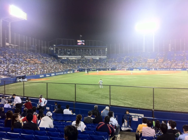 a baseball field with people watching it during the night
