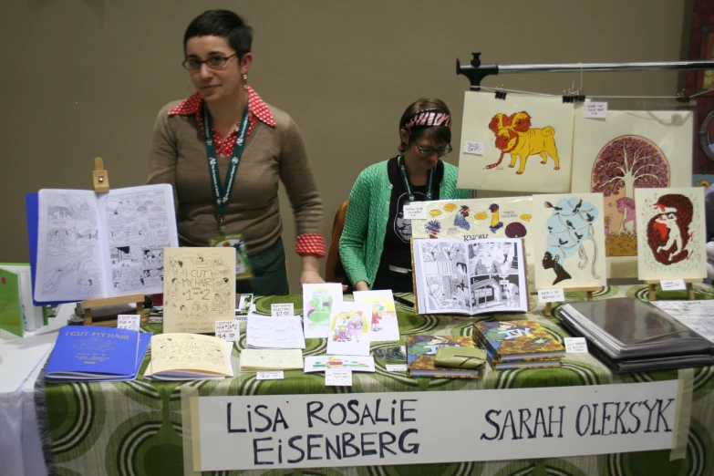 two people that are looking at paintings and cards