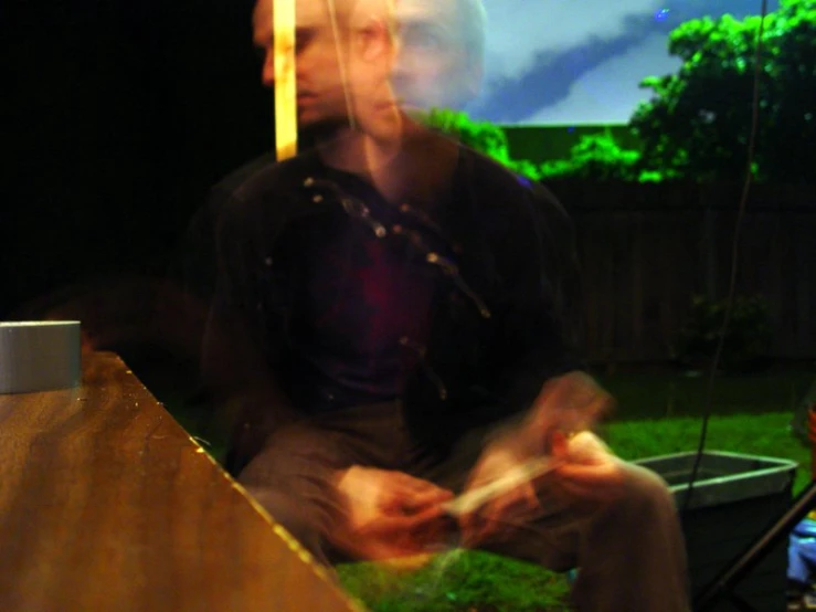 a man sitting on the edge of a wood bench