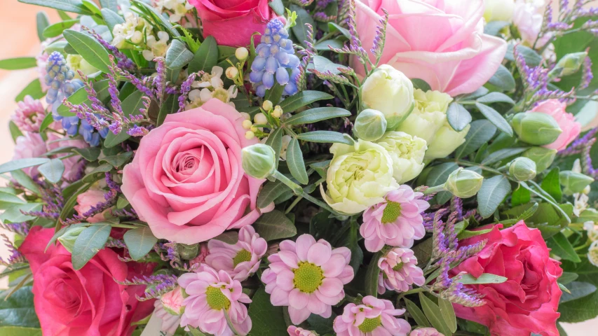 a bouquet of roses and other flowers are displayed