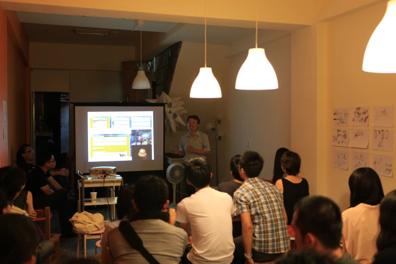 group of people standing in front of a projection screen