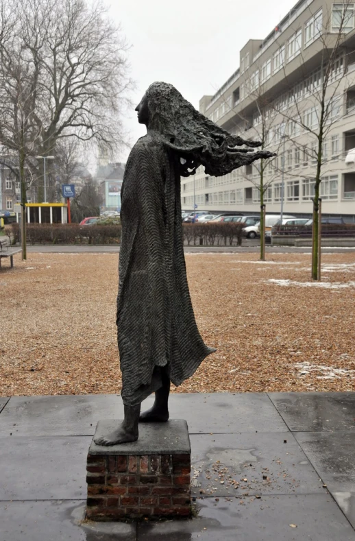 a sculpture with a very large leafed hat and a raincoat