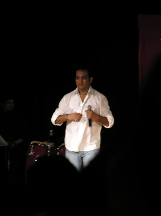 a man in white is talking into a microphone