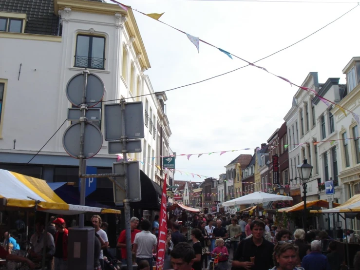 people standing on a city street in front of white buildings