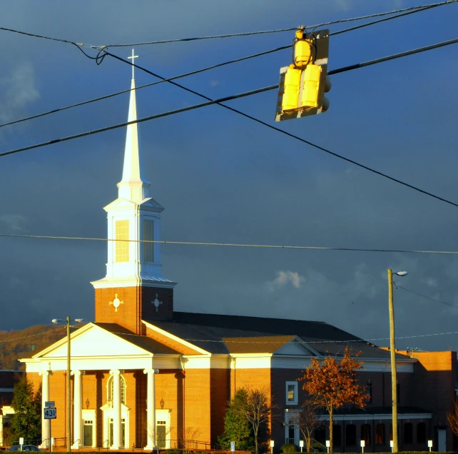 a church building has a traffic light and street lights at the top