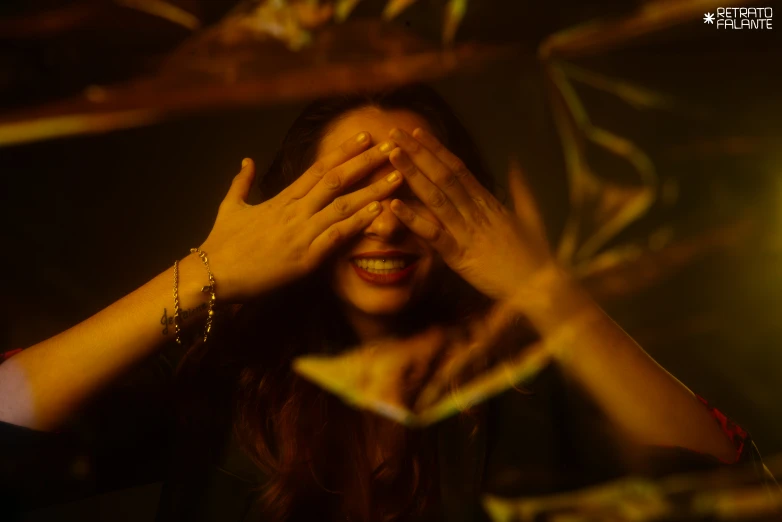 a woman is covering her eyes by her hands