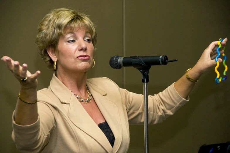 a woman is standing with her hands out and holding up a toy