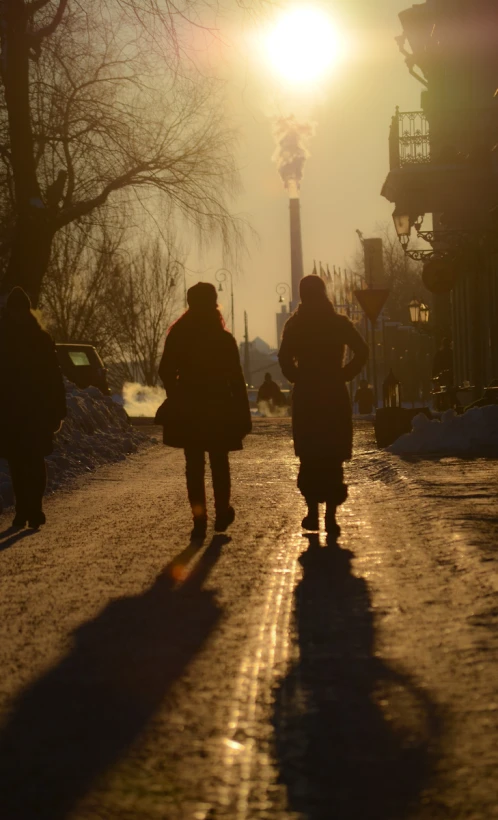 two people walking down the street in the snow