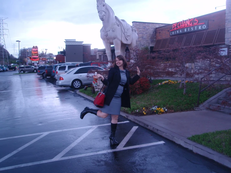 a lady wearing a coat walking down the street with her handbag