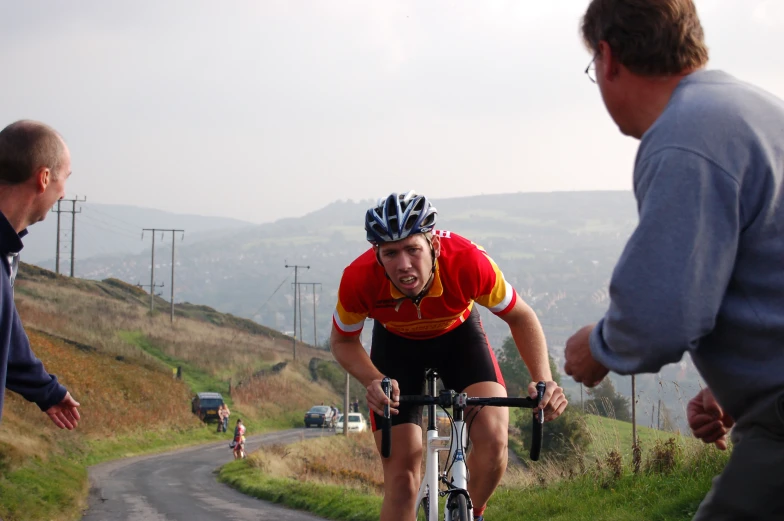 a man wearing a red jersey rides a bike on a mountain road