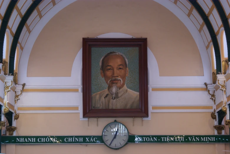 the clock is below a portrait of a man