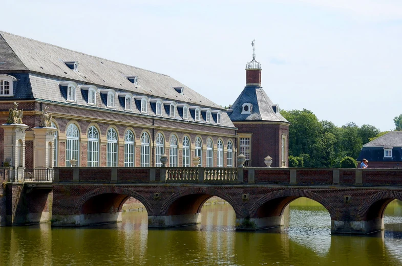 people walking and sitting on bridge over water