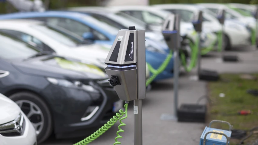 a parking meter in front of a lot of parked cars