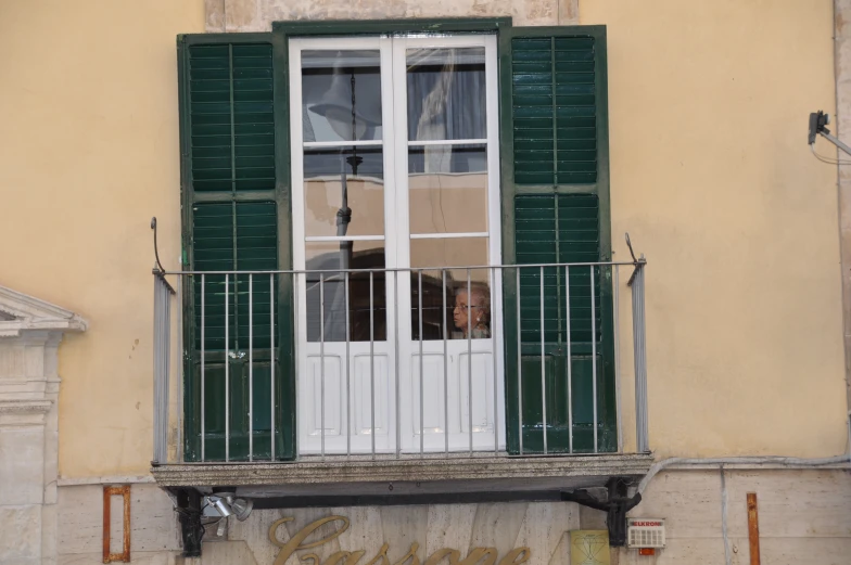 a window with shutters is open next to a balcony