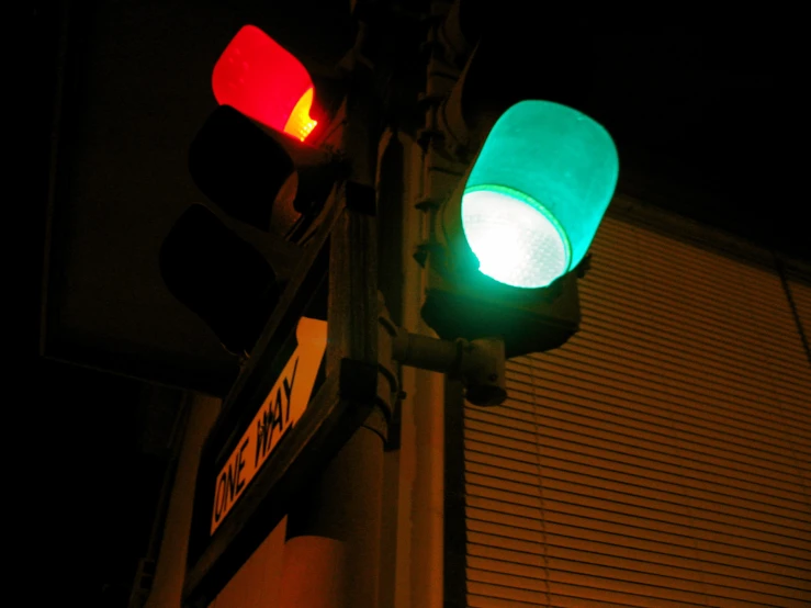 two green traffic lights hanging on the side of a building