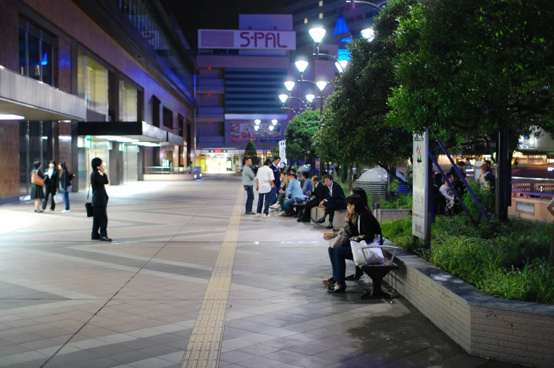 people are sitting on benches by some trees