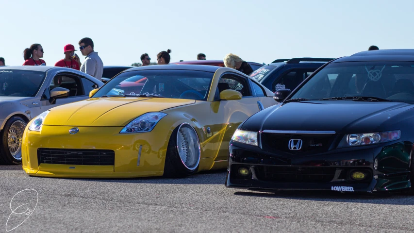 several cars parked on asphalt, one yellow one grey