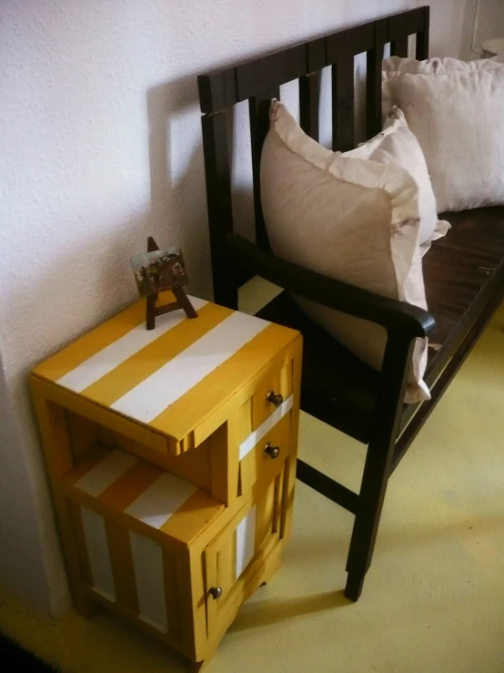 a small bench with a few drawers sitting on it