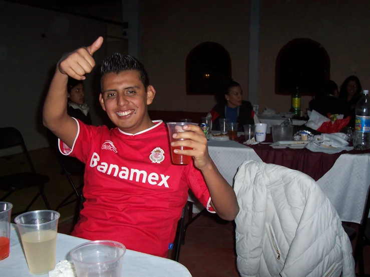 a man sitting at a table holding a glass