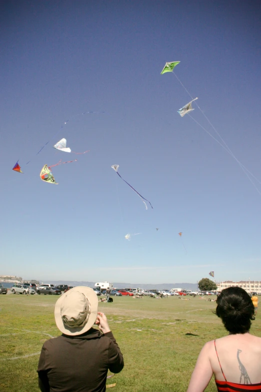 a woman with a hat flying kites in the air