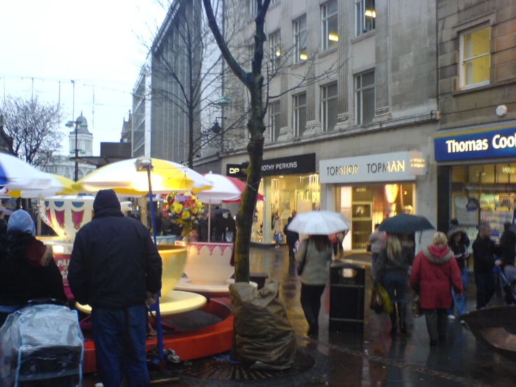 some people are walking down the street with umbrellas