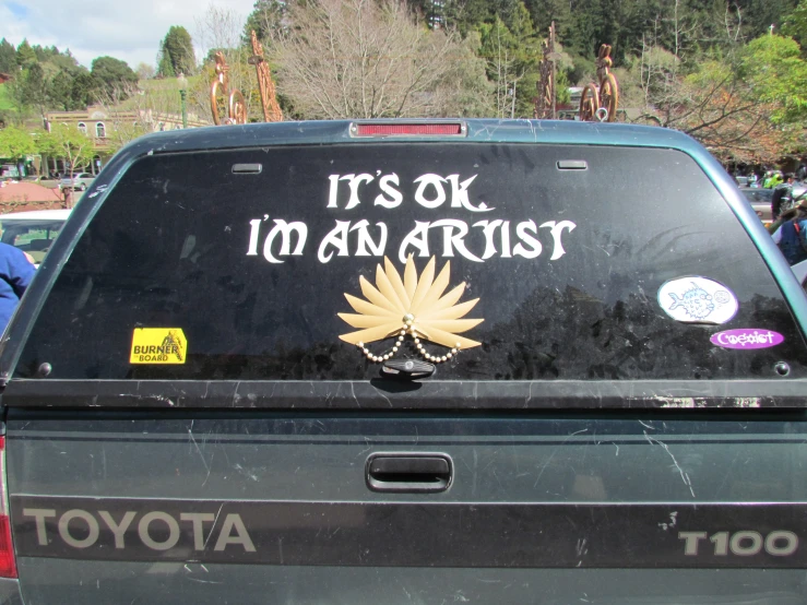 a truck that says it's ok i'm an artist on the back