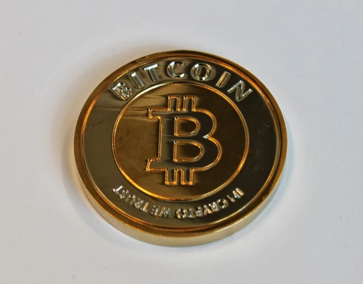 the bitcoin logo is shown on a gold coin