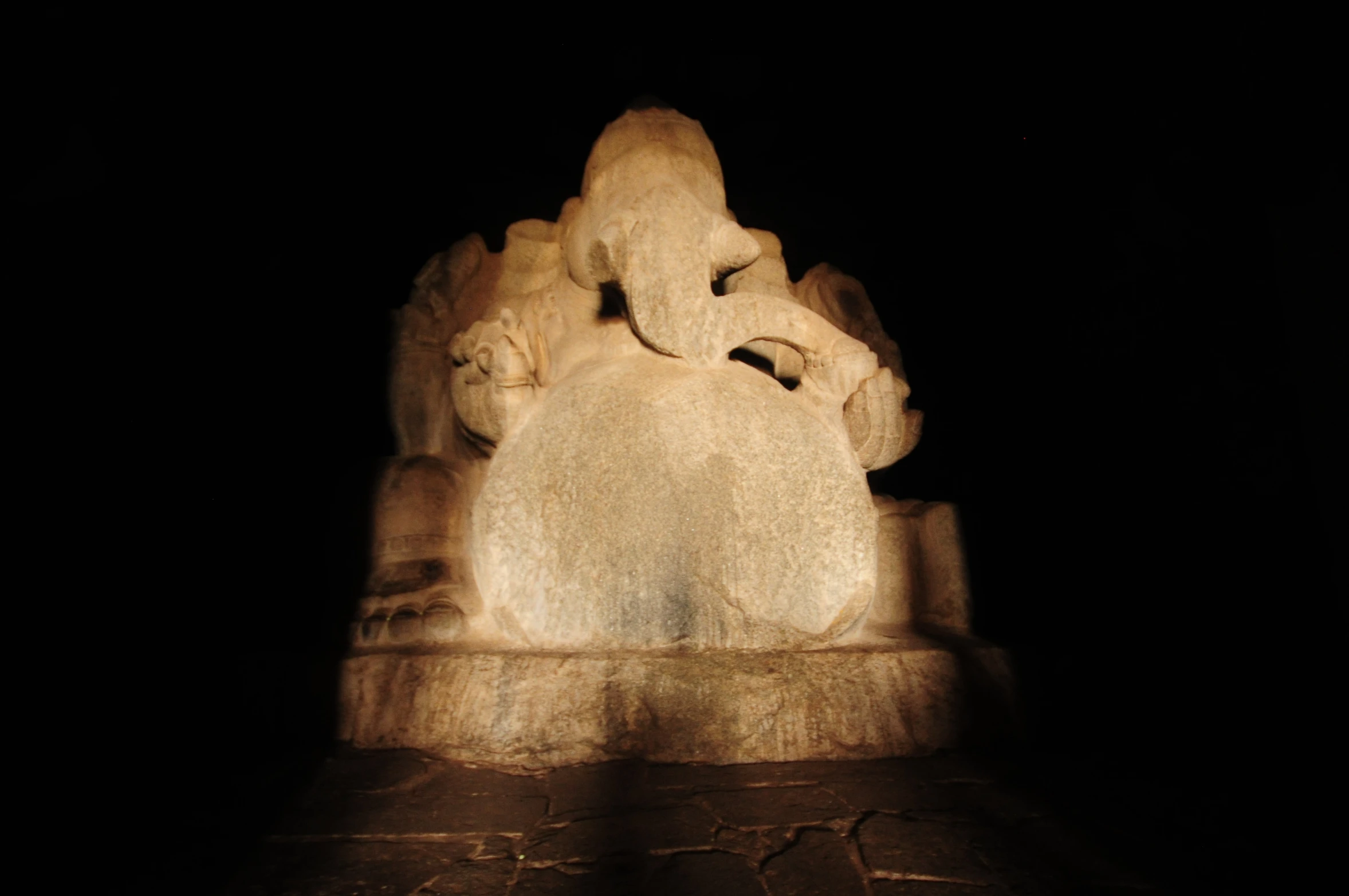 a statue in the dark, on display in a museum