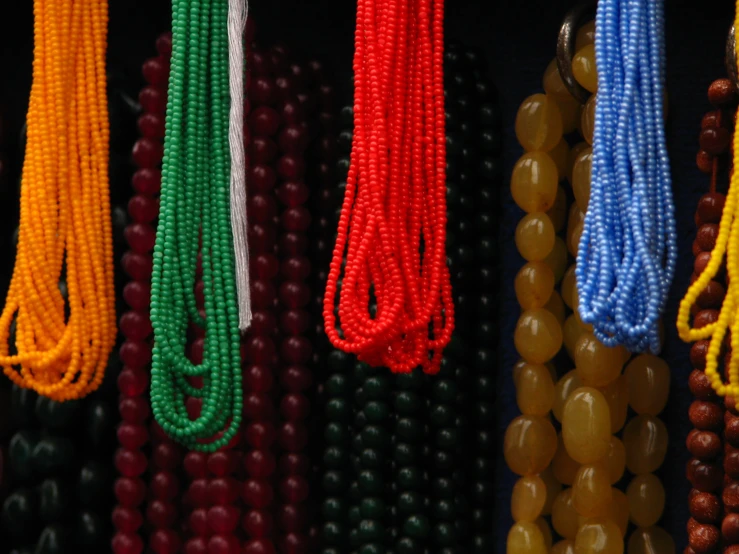 different colored strings on display with beads attached