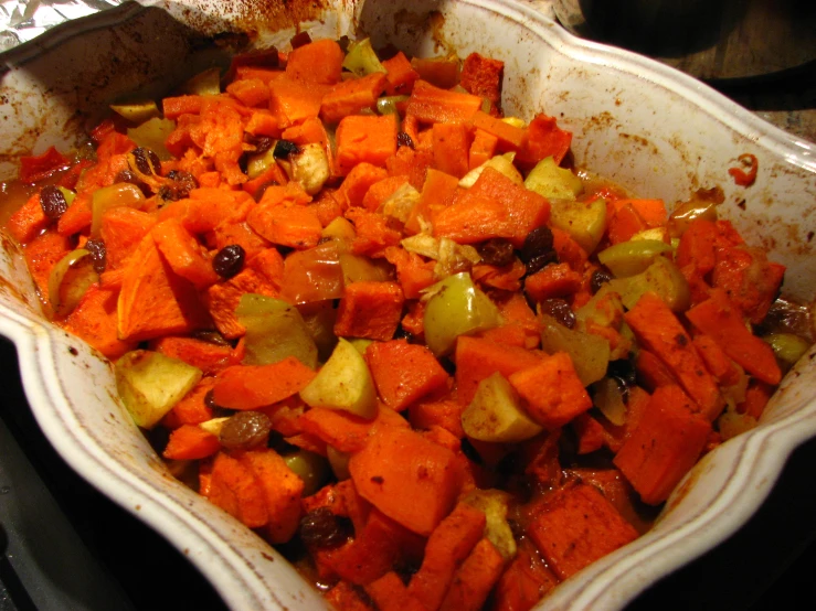 an uncooked dish of cooked vegetables with some seasonings
