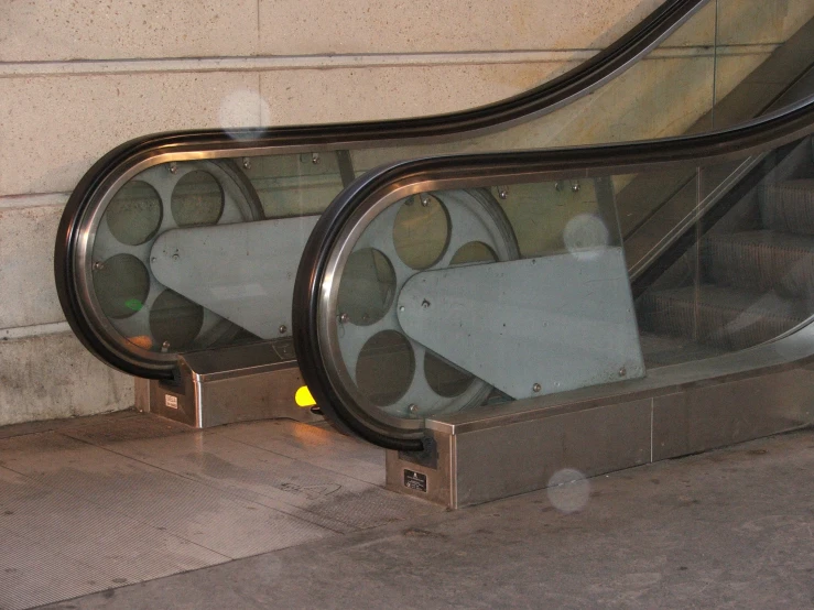 a couple of escalators are sitting in front of a wall